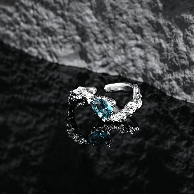 Picture of the Blue Pear Cut Cubic Zircon Adjustable Ring in 925 Sterling Silver in a black texttured background