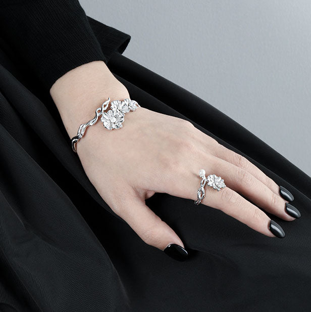 Image of a woman wearing the Floral Shell Pearl Open Bangle in 925 Sterling Silver on her wrist